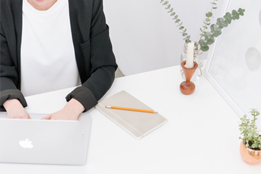 person sitting at desk typing on laptop